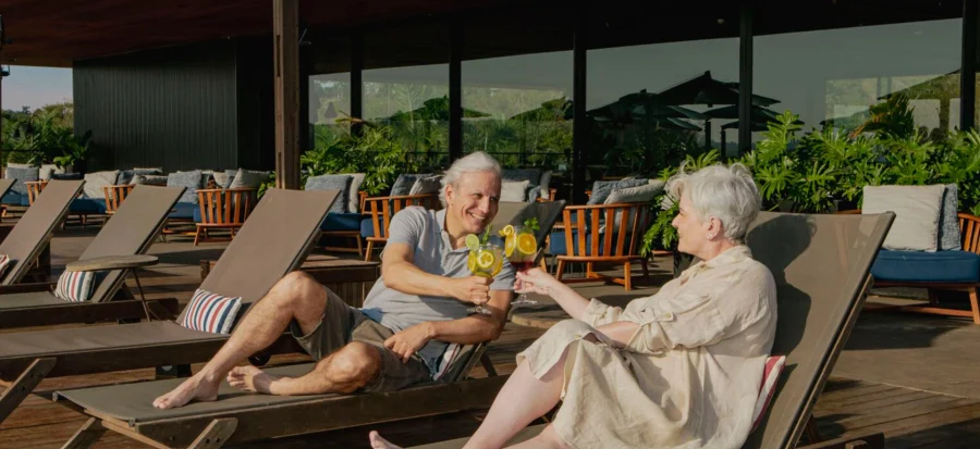casal de idosos brindando a beira da piscina