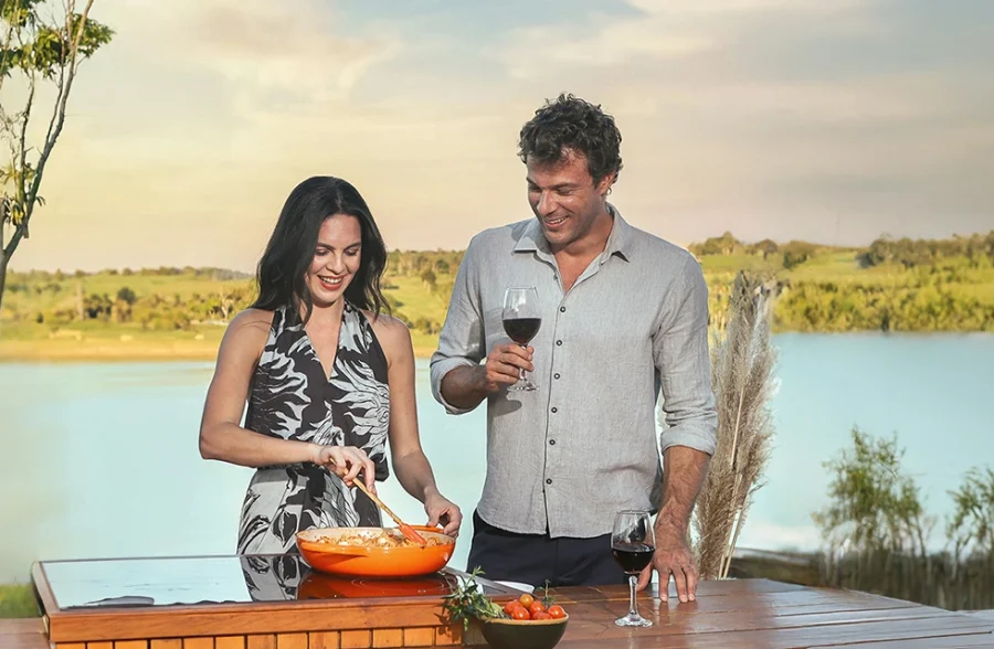 casal cozinhando a beira da represa do resort
