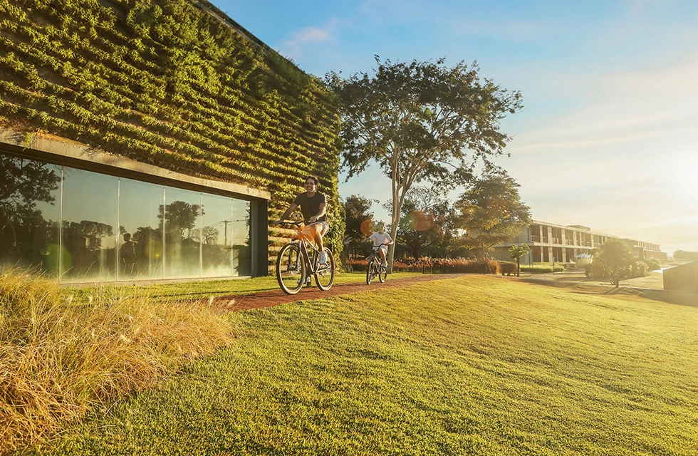 pai e filha andando de bike pelos arredores do clara dourado durante a tarde de um fim de semana de férias no resort