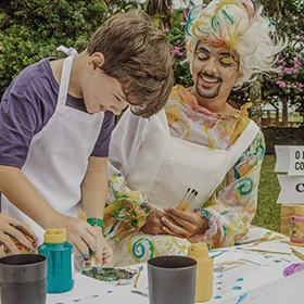 animador de festa junto de uma criança hóspede do resort para atividades recreativas no local; um momento para explorar a criatividade junto à natureza