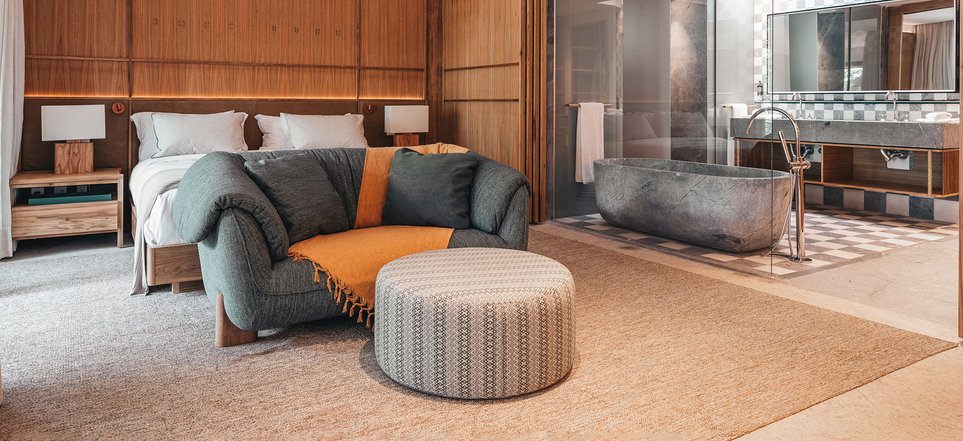 quarto amplo de hóspede com sofá confortável, cama e banheira 