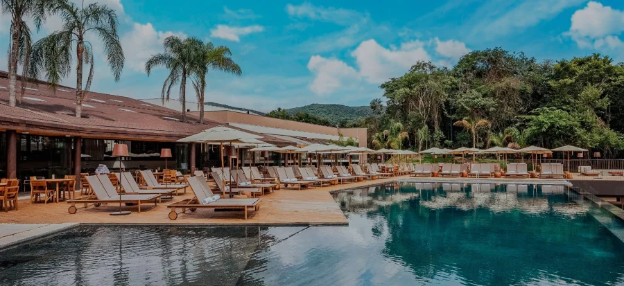 vista da piscina externa com espreguiçadeiras e guarda-sol