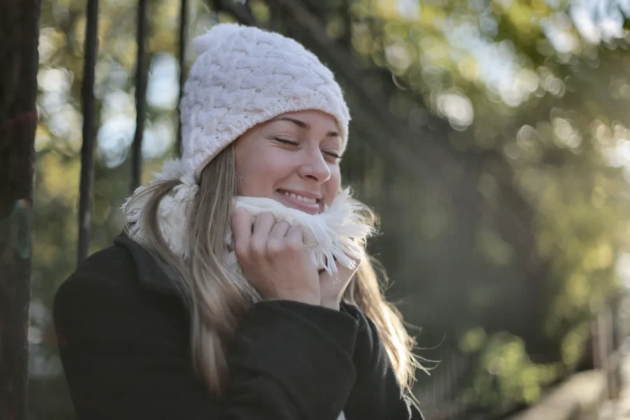 Mulher contemplando o frio em viagem no resort nas suas ferias de inverno